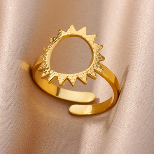 Close-up of golden sunburst open ring on luxury pink satin fabric background