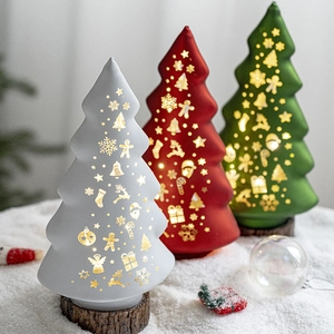 Luminous glass Christmas tree ornaments with festive glowing patterns on a snowy tabletop