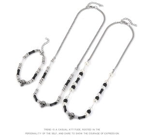 Macro detail of skull jewelry set with black beads and silver skull pendants