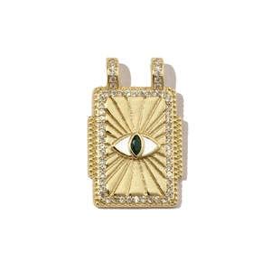 Makrodetail eines goldenen Evil Eye Anhängers mit weißem Zirkonia und grünem Edelstein