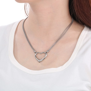 Detail of hollow heart pendant with sparkling crystals on a double layer steel chain
