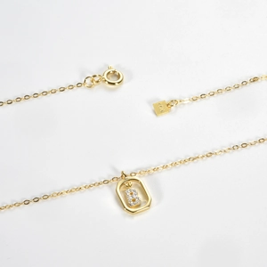 Macro shot of S925 silver necklace featuring a gold square pendant with a diamond letter B