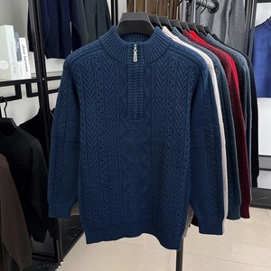Detail of navy blue cable knit sweater with stand collar and metallic half zipper