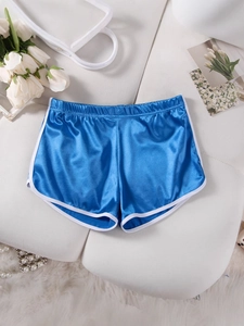 Blue retro satin sports shorts with white trim laid on white plush background