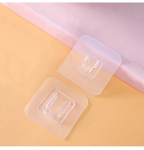 Macro view of clear adhesive double-sided wall hooks with interlocking buckle design