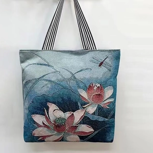 Detailed close-up of a canvas tote bag with lotus flower prints and striped handles