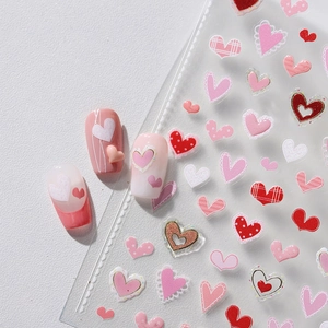 3D heart nail art stickers with red and pink patterns on gradient press-on nails