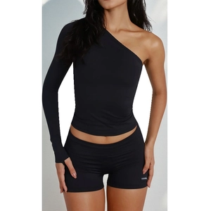 Detail view of black two-piece set with one-shoulder top and FASHION print shorts