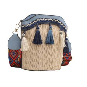 Close-up of beige woven bucket bag with blue fringe tassels and ethnic strap detail