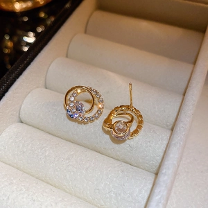 Macro shot of gold-plated hoop earrings with sparkling cubic zirconia on a velvet display