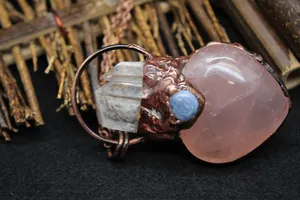 Detail of pink crystal heart pendant with quartz points and vintage copper finish