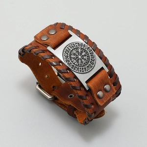 Detail of Viking compass engraving on brown leather woven bracelet with metal plate