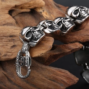 Gothic skull link bracelet in vintage stainless steel on rustic wood background