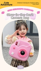 Zaino rosa a forma di fotocamera per bambini con ciondolo a fiore su una piccola modella
