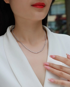 Close-up of S925 sterling silver tennis necklace with sparkling moissanite stones on neck