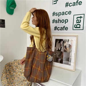 Large plaid woolen tote bag shown being carried by an Asian model in lifestyle.