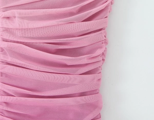 Macro scatto di tessuto a rete rosa con trama a pieghe dettagliata e maglia sottile