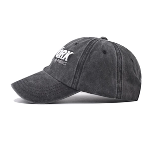 Close-up of white YORK embroidery on vintage black washed cotton baseball cap