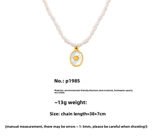 Detailed view of freshwater pearl necklace with gold shell pendant and white shell inlay