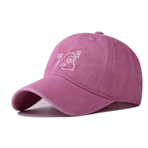 Detailed macro view of magenta washed cotton baseball cap with palm tree embroidery