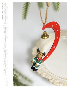 Macro detail of Christmas reindeer figurine on red crescent moon with metal bell