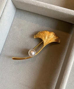 Dettaglio della spilla a foglia d'acero in oro 18K spazzolato con perla tonda