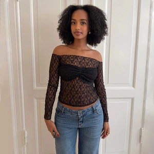 Haut moulant en dentelle noire à épaules dénudées, manches longues et transparent
