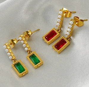 Detail of square-cut emerald and ruby drop earrings with small pearls in gold finish