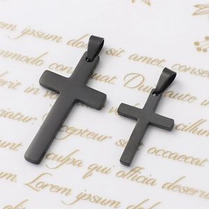 Detail view of two black matte stainless steel cross pendants in different sizes