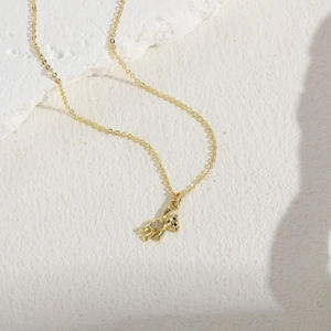Close-up of golden teddy bear pendant with sparkling zircon inlays on white minimalist base
