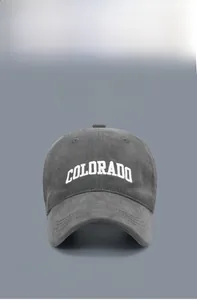Detailed embroidery of white COLORADO text on a dark grey corduroy baseball cap texture
