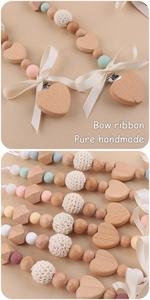 Detail of handmade pacifier clips with wooden hearts, crochet beads and ribbon bows