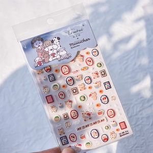 Detail view of thin nail stickers featuring cartoon dogs and bears on a snowy background
