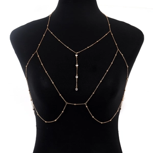 Close-up of golden body chain with four sparkling diamond pendants on a black mannequin