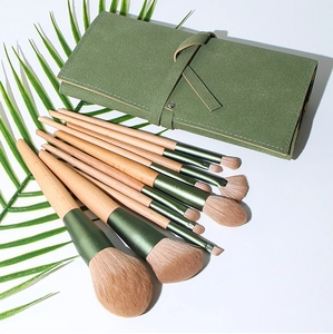 Detail of 10-piece makeup brush set with green wooden handles and suede storage roll