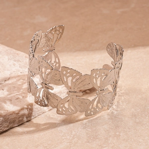 Detail of silver hollow butterfly cuff bracelet with intricate wing textures on stone