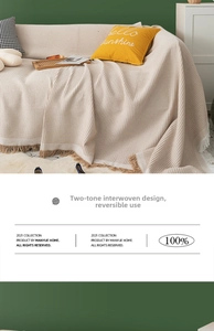 Detail of beige waffle weave sofa blanket with tassels and dual-color weaving design