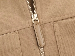 Détail du sergé kaki montrant la fermeture éclair en métal, tirette cuir et coutures