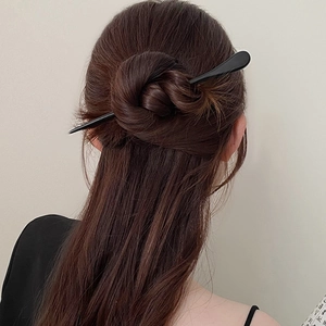 Épingle à cheveux noire minimaliste présentée sur une coiffure élégante de mannequin