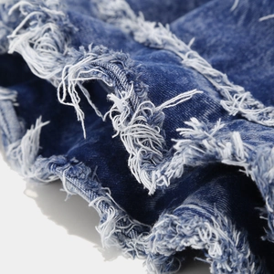 Detailed close-up of frayed edges and washed denim texture on a vintage sun hat