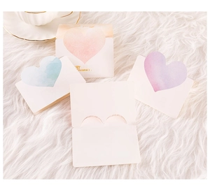 Detailed view of foldover thank you cards with heart cutouts on a soft fur surface