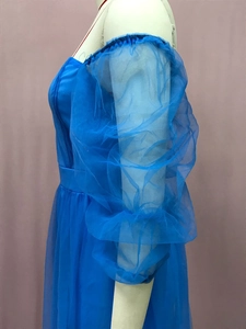 Detail eines eleganten schulterfreien Abendkleids in Blau mit bauschigen Tüllärmeln