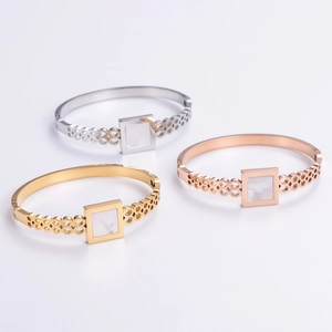 Set of three geometric cutout stainless steel bangles in gold, silver, and rose gold