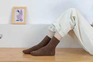 Close-up of thick dark brown coral fleece socks worn on feet for winter warmth
