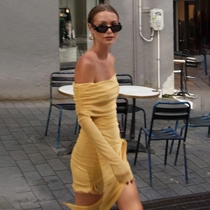 Robe courte jaune à épaules dénudées avec manches longues et détails froncés dans la rue