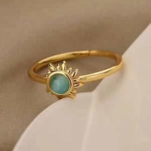 Detailed view of adjustable golden sun ring with light blue-green round cat's eye stone