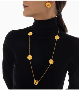 Goldenes Wabenhalsketten- und Sonnenblumenohrringset auf schwarzem Rollkragenpullover