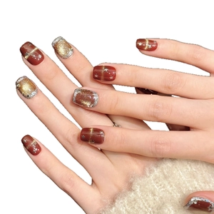 Handmade burgundy press-on nails with gold star patterns and glitter finish