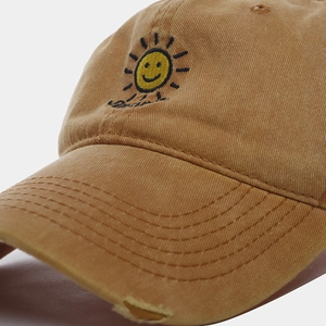 Close-up of vintage washed cotton baseball cap with sun embroidery and distressed brim