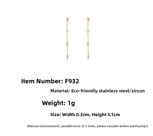 Détail de boucles d'oreilles pampilles en acier doré avec zircons blancs, long. 5,1 cm